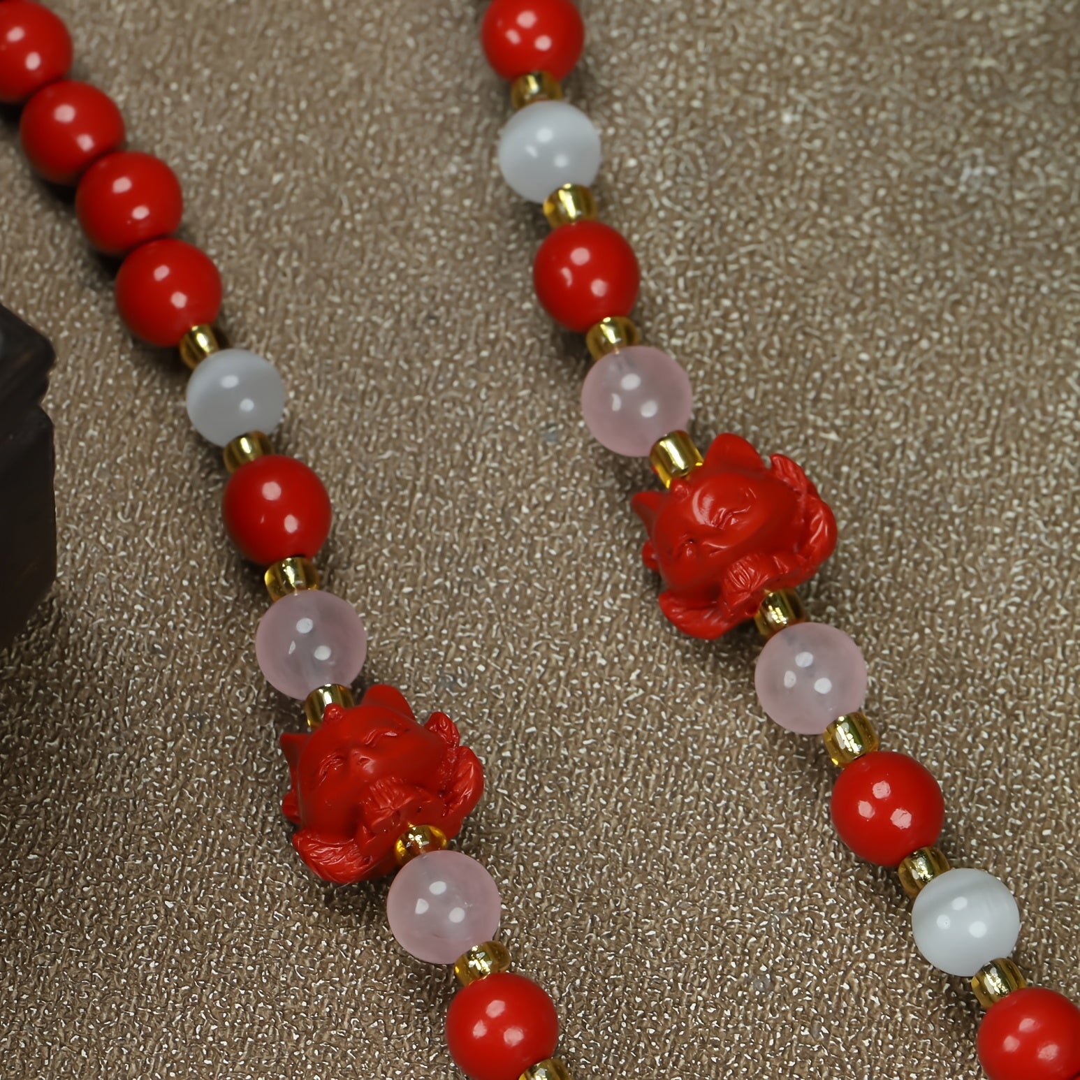 Detail of cinnabar beads and carved rose pendant