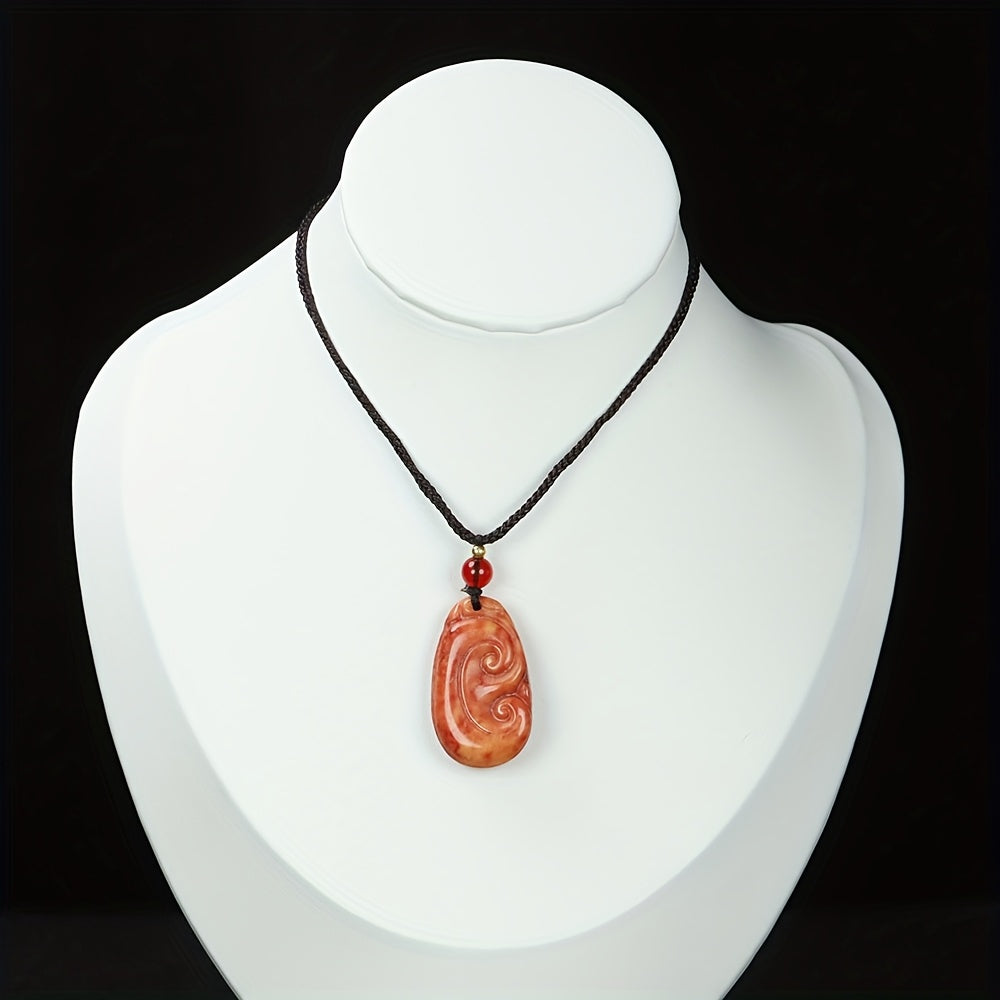 A jasper pendant with a beautifully carved swirl design, showcasing the symbol's timeless elegance.
