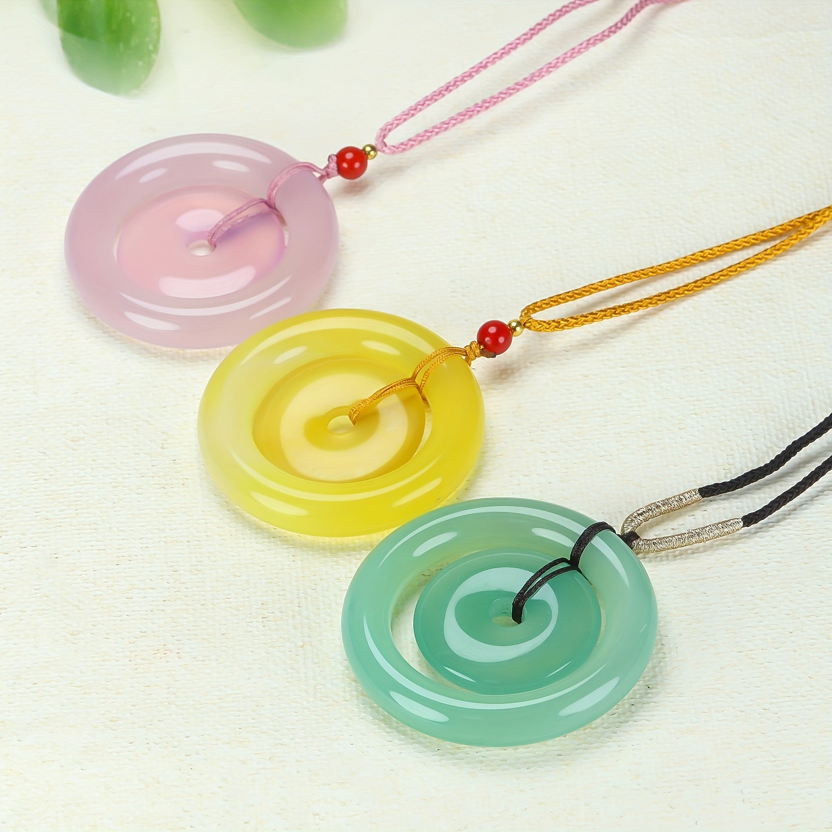 Tri-color agate peace pendant displaying yellow, pink, and green stones