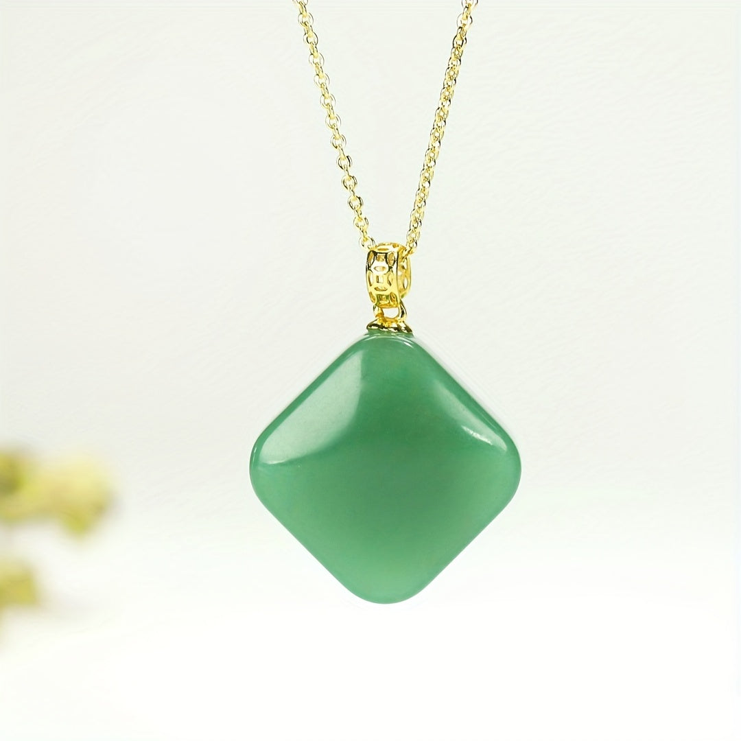 Close-up of hand holding square pendant demonstrating tactile connection