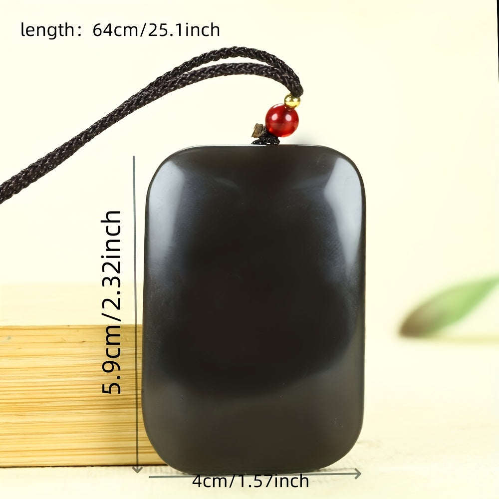 Close-up of black obsidian pendant and red bead